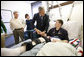 President George W. Bush shakes hands with U.S. Army Staff Sgt. Kyle Stipp of Avon, Ind., after presenting him with two Purple Hearts Monday, Dec. 22, 2008, during a visit to Walter Reed Army Medical Center where the soldier is recovering from wounds suffered in Operation Iraqi Freedom. Looking on are his wife, Megan, and father, Mitch Stipp. White House photo by Eric Draper