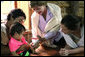 Mrs. Laura Bush and daughter Barbara Bush, show a camera to a young family at the Mae La Refugee Camp August 7, 2008, in Mae Sot, Thailand. White House photo by Shealah Craighead