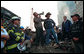 With retired firefighter Bob Beckwith standing next to him, President George W. Bush uses a bullhorn to address rescue workers Sept. 14, 2001, at Ground Zero, the site of the terrorist attack on the World Trade Center. White House photo by Eric Draper