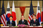 President George W. Bush sits with President Roh Moo-Hyun, of the Republic of Korea, left, and Japan's Prime Minister Shinzo Abe during a trilateral discussion Saturday, Nov. 18, 2006, at the Sheraton Hanoi hotel in Hanoi, where they are participating in the Asia Pacific Economic Cooperation summit. White House photo by Eric Draper