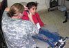 Capt. Lori August gives an Iraqi child a hearing exam, Dec. 28, 2008.  Photo by 1st Cavalry Division Public Affairs.