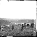 Long view of soldiers camping in a field
