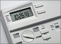 Photo of a programmable thermostat. The time reads 10:26 and the temperature is 55 degrees Fahrenheit. Copyright iStockphoto.com/Paul Kazmercyk.
