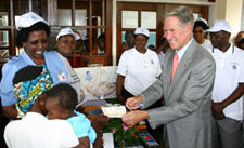 Photo of the U.S. Ambassador Michael Retzer provides an Infant Bed Net Voucher to a woman in Morogoro, Tanzania