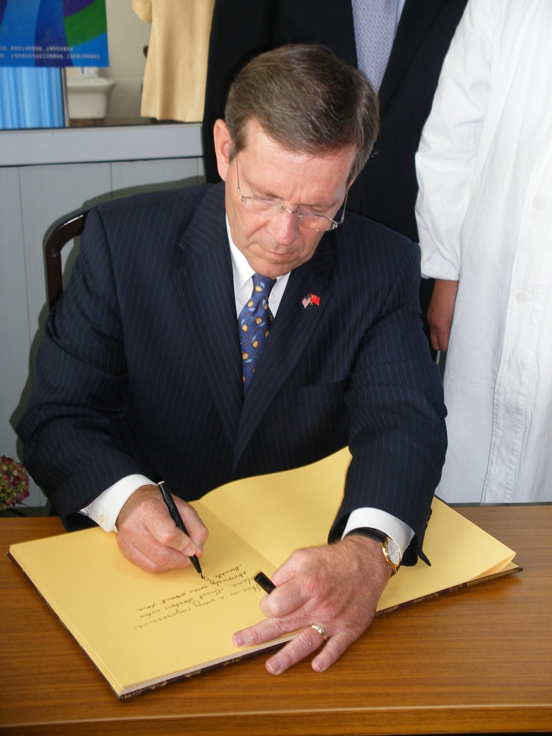 Secretary Leavitt signing a message in a book of patient stories at a methodone clinic in Shanghai
