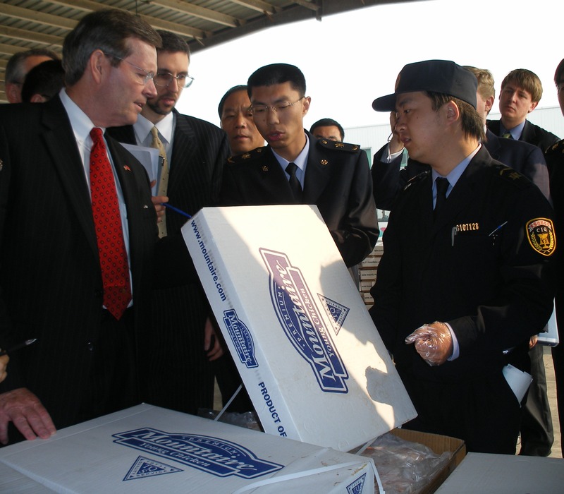 HHS Secretary Mike Leavitt joined by Chinese inspectors looks at chicken shipped from the U S  to the Port of Shanghai China's largest port