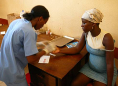 Photo of a pregnant woman receiving malaria medication in Angola