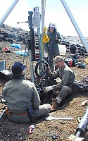 Volunteers help install a tiltmeter into a hole about 3 m deep