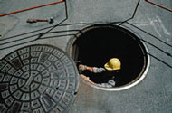 Worker entering manhole