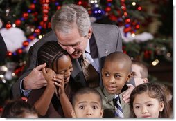 President George W. Bush embraces a group of youngsters Monday, Dec. 8, 2008, as he welcomes children attending the Children's Holiday Reception and Performance at the White House.  White House photo by Eric Draper