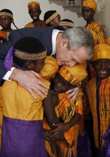 Photo of President George W. Bush embracing members of the African Children's Choir Wednesday, July 30, 2008, thanking them for their musical performance at the White House.