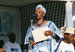 Photo of a woman reading a poem during the PMI kickoff festivities in Zanzibar, supported by a string orchestra and USAID/Tanzania and Kataa Malaria banners in the background. (click here to see more)