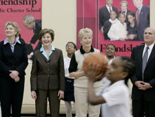 Mrs. Bush, joined by Ambassador Karen Hughes left, and Linda Hargrove, Washington Mystics, and Admiral Tim Ziemer, watch students play basketball at the Friendship Public Charter School in Washington, D.C.