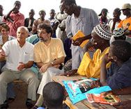 Photo of U.S. Malaria Coordinator Admiral R. Timothy Ziemer and USAID/Senegal Director Olivier Carduner addressing residents outside the health hut in Yabo Yabo in Senegal's Thiadiaye health district.
