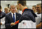 President George W. Bush holds the Olympic gold medal of U.S. Olympic swimmer Michael Phelps, after congratulating Phelps on his first Olympic gold performance Sunday, Aug. 10, 2008, at the National Aquatics Center in Beijing. White House photo by Eric Draper