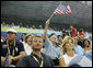 President George W. Bush, accompanied by Mrs. Laura Bush, waves an American flag as he cheers for the U.S. Olympic swimming team Monday, Aug. 11, 2008, in the National Aquatic Center at the 2008 Summer Olympic Games in Beijing. White House photo by Eric Draper