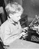 Boy typing on a typewriter at Chicago Daily News sanitarium