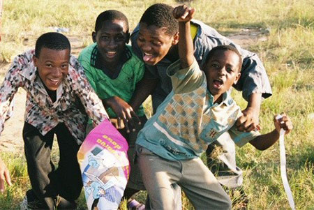 Photo of four children playing during the PMI kickoff in Tanzania.