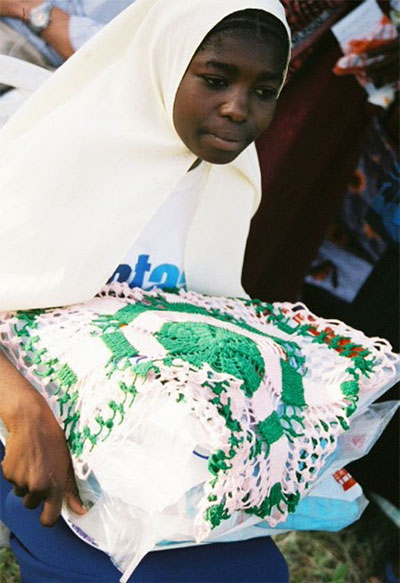 Photo of a young mother receiving a long-lasting net at the PMI launch in Tanzania.