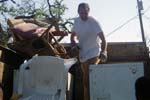 Sandy Scott, Director of Public Affairs for the Corporation for National and Community Service, lends a hand loading debris into a truck in Pass Christian, Miss.