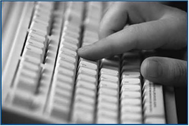 Photograph of a hand on a computer keyboard.