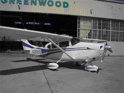 Cessna Turbo 206 parked by hanger