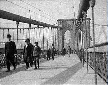 Men and boys walking across a bridge.