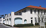 Photo: large white stucco building with a red tile roof.