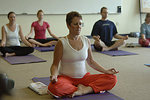 Participants in a yoga class  meditating while in the lotus pose. © Bob Stockfield