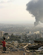 From the hills overlooking Beirut, a child watches smoke rise from Rafiq Hariri Airport following Israeli air strikes.