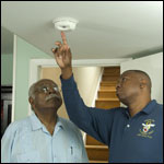 Photo: Two men discussing features of a fire alarm