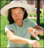 Photo: Woman applying insect repellent