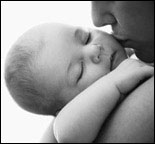 Photo: A mother kissing a sleeping baby.