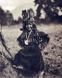 Young Indian in costume posing by a tree
