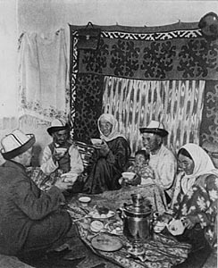 A Kyrgyz family in a traditional setting, drinking tea in a yurt