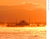 A ferryboat travels across Lake Champlain as the sun drops