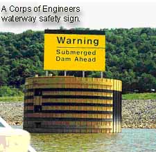 Photo of a buoy with a sign reading Warning, Submerged Dam Ahead.