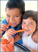 Boy and girl eating carrots