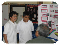 Excitement shows on the faces of two young scientists as they describe to Dan White the process they used and the results they discovered