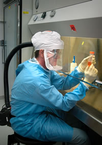CDC scientist examining specimens in BSL-3 Lab