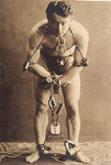 Harry Houdini, full-length portrait, standing, facing front, in chains. LC-USZC4-3277