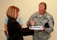 Sgt. Benjamin Walker, Army Reserve recruiter and acting station manager for the Scottsdale Army Recruiting Station, signs a form from Debbie Mitchell, Asset Management specialist for the U.S. Army Corps of Engineers Los Angeles District, accepting the work done by the Corps on the new recruiting station in Scottsdale, Ariz. Oct. 16. The Corps created separate new office space for the Scottsdale Army, Navy and Marine Corps recruiters in what was once a 3,200 square foot single-tenant area. (Photo by Daniel J. Calderón)