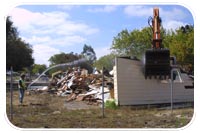 A construction worker hoses down a section of a house to keep dust from flying as it is town down in August. This section of the former Vandenberg East housing area was demolished during the Phase one through Phase Three demolition project just outside Vandenberg AFB.