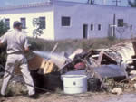 Man spraying liquid on debris