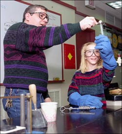 Photo: a man and a young girl working with materials in a lab.