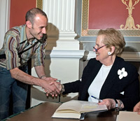 Madeleine Albright shaking hands with a man at a book signing.