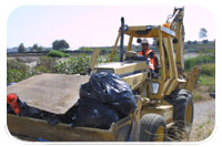 Florindo Aguilar, an L.A. District employee for the U.S. Army Corps of Engineers, drives his backhoe full of trash to an awaiting five-ton dump truck. Aguilar, other Corps employees and volunteers from the local community, were on hand at Compton Creek near the Crystal Park Casino and Resort Sept. 15 for Coastal Cleanup Day.