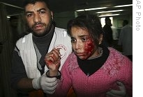 A Palestinian medic walks with a wounded girl who according to Palestinian medical sources was injured in Israeli forces' operations in Gaza, Tuesday, 06 Jan. 2009