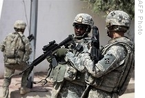 US soldiers patrol site of an explosion in a Christian market in Baghdad's Dora district, 15 Oct. 2008