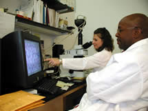 Photo of two CDC microbiologists and telediagnosis equipment